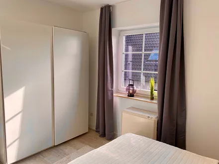 Schlafzimmer mit Doppelbett (1,80 m x 2,00 m), Nachttischablagen, Kleiderschrank und großem Spiegel sowie Insektenschutz