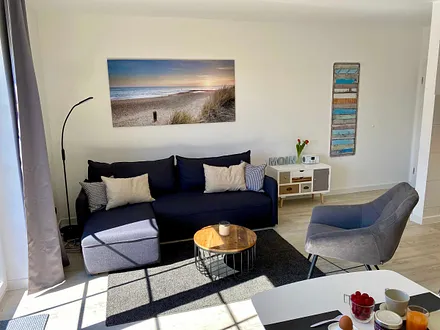 Wohnbereich mit komfortabler Eckcouch/Schlafcouch (Aufbettung für 3./4. Person 1,40 m x 1,90 m inklusive Bettkasten),Sessel,Couchtisch,Smart TV,Designleselampe,dimmbare LED Lichtschienen & Sideboard