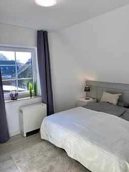 Schlafzimmer mit Doppelbett (1,80 m x 2,00 m), Nachttischablagen, Kleiderschrank und großem Spiegel sowie Insektenschutz