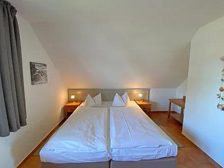 Schlafzimmer mit Doppelbett (1,80 m x 2,00 m), Nachtischablagen und Kleiderschrank 