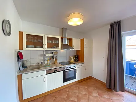 Küchenzeile mit Geschirrspüler, Mikrowelle, Ceranfeld, Backofen, Kühlschrank, Wasserkocher, Toaster, Kaffeemaschine und diversen Küchenutensilien 