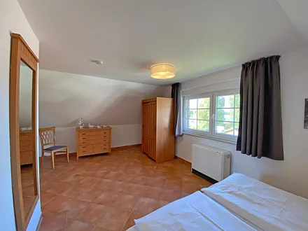 Schlafzimmer mit Doppelbett (1,80 m x 2,00 m), Nachtischablagen und Kleiderschrank 