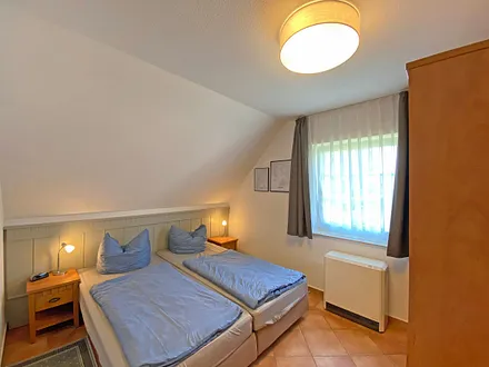 Schlafzimmer mit Doppelbett (1,80 m x 2,00 m), Nachttischablagen und Kleiderschrank