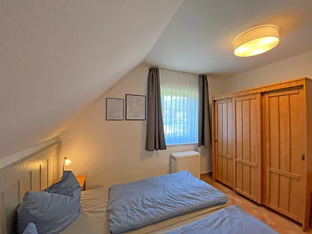 Schlafzimmer mit Doppelbett (1,80 m x 2,00 m), Nachttischablagen und Kleiderschrank