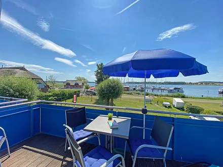 großer bestuhlter Balkon (West) mit Sonnenschirm und Panoramablick auf den Selliner See 