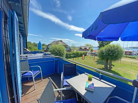 großer bestuhlter Balkon (West) mit Sonnenschirm und Panoramablick auf den Selliner See 