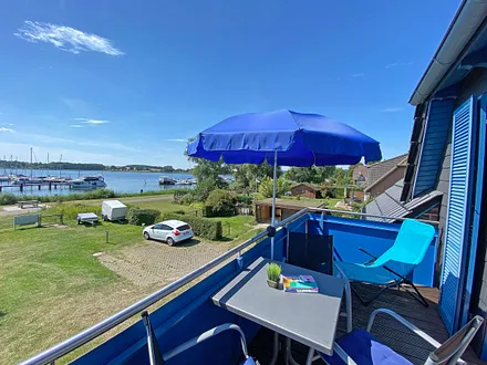 großer bestuhlter Balkon (West) mit Sonnenschirm und Panoramablick auf den Selliner See 