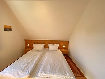 Schlafzimmer mit Doppelbett (1,80 m x 2,00 m), Nachttischablagen und Kleiderschrank 