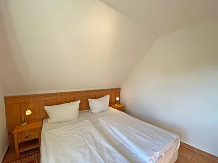 Schlafzimmer mit Doppelbett (1,80 m x 2,00 m), Nachttischablagen und Kleiderschrank 