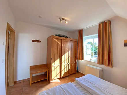 Schlafzimmer mit Doppelbett (1,80 m x 2,00 m), Nachttischablagen und Kleiderschrank 