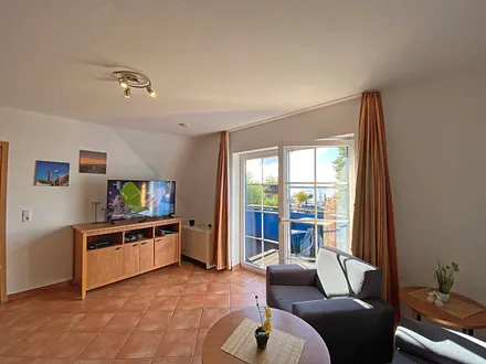 Wohnbereich mit Massivmöbeln, Stehlampe, Sessel und einer Schlafcouch (Aufbettung für 3./4. Person, 1,90 m x 1,40 m), Gesellschaftsspielen, 42 Zoll Smart-TV & Mini-Stereo-Anlage mit DAB Radio