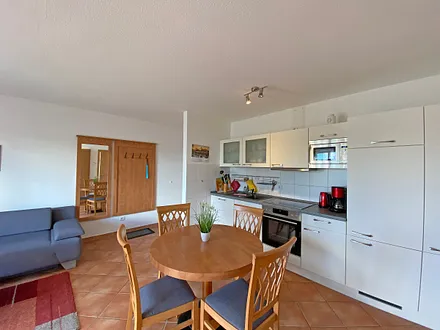 Küchenzeile mit Geschirrspüler, Mikrowelle, Ceranfeld, Backofen, Kühlschrank mit Gefrierfach, Wasserkocher, Toaster, Kaffeemaschine und diversen Küchenutensilien 