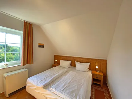 Schlafzimmer mit Doppelbett (1,80 m x 2,00 m), Nachttischablagen und Kleiderschrank 