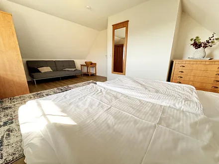 Schlafzimmer mit Doppelbett (1,80 m x 2,00 m), Nachttischablagen, Kleiderschrank sowie eine Couch (1,10m x 1,90m) als Aufbettung für das Kind