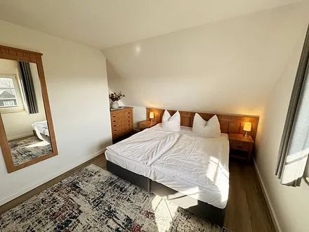 Schlafzimmer mit Doppelbett (1,80 m x 2,00 m), Nachttischablagen, Kleiderschrank sowie eine Couch (1,10m x 1,90m) als Aufbettung für das Kind