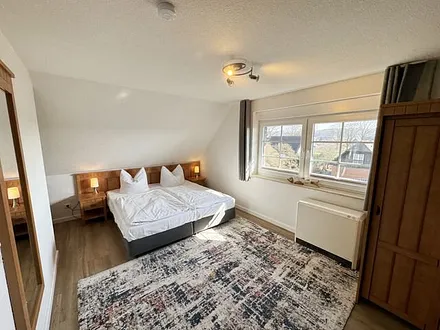 Schlafzimmer mit Doppelbett (1,80 m x 2,00 m), Nachttischablagen, Kleiderschrank sowie eine Couch (1,10m x 1,90m) als Aufbettung für das Kind