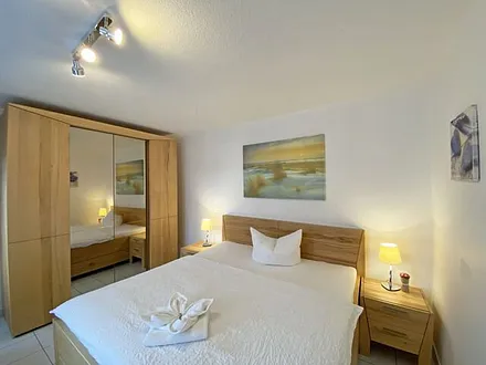 Schlafzimmer mit Doppelbett (á 0,90m x 1,90m) und ein Einzelbett (0,90m x 1,90m),verstellbare Lattenroste, Nachttischkonsolen sowie ein Kleiderschrank