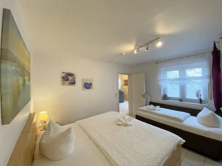 Schlafzimmer mit Doppelbett (á 0,90m x 1,90m) und ein Einzelbett (0,90m x 1,90m),verstellbare Lattenroste, Nachttischkonsolen sowie ein Kleiderschrank