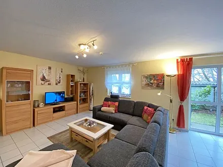 Wohn-/ Essbereich mit Essecke, gemütliche Couchecke (mit Ausziehfunktion 1,40m x 2,10m), Tisch, Anrichte, Leselampe, Flachbild-TV und Blu-Ray-Player