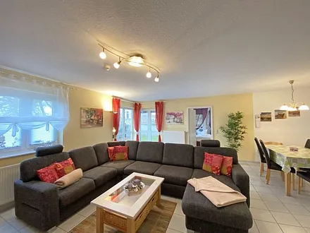 Wohn-/ Essbereich mit Essecke, gemütliche Couchecke (mit Ausziehfunktion 1,40m x 2,10m), Tisch, Anrichte, Leselampe, Flachbild-TV und Blu-Ray-Player