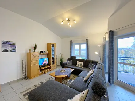 Wohnzimmer mit gemütlicher Couchecke (Ausziehfunktion 1,10 m x 2,00 m), Couchtisch, Leselampe, Anrichte, Flachbild-TV und Mini-Stereo-Anlage