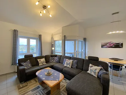 Wohnzimmer mit gemütlicher Couchecke (Ausziehfunktion 1,10 m x 2,00 m), Couchtisch, Leselampe, Anrichte, Flachbild-TV und Mini-Stereo-Anlage