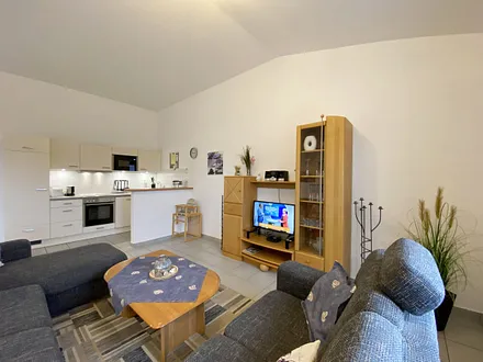 Wohnzimmer mit gemütlicher Couchecke (Ausziehfunktion 1,10 m x 2,00 m), Couchtisch, Leselampe, Anrichte, Flachbild-TV und Mini-Stereo-Anlage