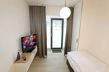 Schlafzimmer mit einem Einzelbett (0,90 m x 2,00 m), Nachttischablage mit Beleuchtung und USB Anschlüssen sowie einem Kleiderschrank