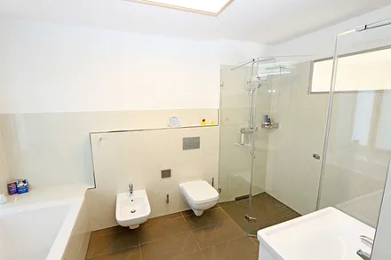 Bäder mit jeweils einem WC, ebenerdiger Dusche, Kosmetikspiegel, Fön, Handtuchtrockner sowie einem Waschplatz mit großzügigem Spiegel und Ablagefläche