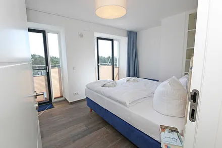 Schlafzimmer mit Boxspringbetten ( Doppelbett 1,60 m x 2,00 m ), Smart-TV, Nachttischablagen mit Beleuchtung und USB-Anschlüssen sowie Kleiderschränken