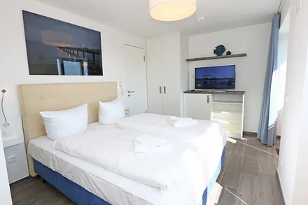 Schlafzimmer mit Boxspringbetten ( Doppelbett 1,60 m x 2,00 m ), Smart-TV, Nachttischablagen mit Beleuchtung und USB-Anschlüssen sowie Kleiderschränken