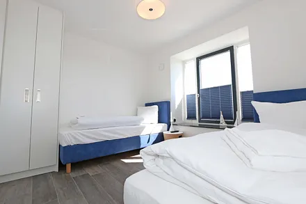 Schlafzimmer mit Boxspringbetten ( Einzelbetten je 0,90 m x 2,00 m ), Smart-TV, Nachttischablagen mit Beleuchtung und USB-Anschlüssen sowie Kleiderschränken