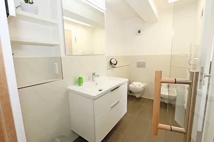 beide Badezimmer mit WC, ebenerdigen Dusche, Kosmetikspiegel, Fön, Handtuchtrockner sowie Waschplatz mit großzügigen Spiegeln und Ablageflächen