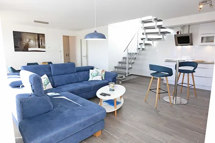 großzügiger Wohn-/Essbereich mit komfortabler Eckcouch, Couchtisch, Sideboard, Stehlampe, Smart-TV, Blu-ray Player, Mini-Stereo-Anlage mit Bluetooth und USB-Anschluss