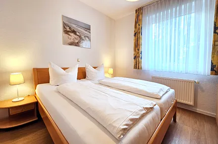 Schlafzimmer mit Doppelbett & Kleiderschrank (Verdunklungsjalousie vor dem Fenster)