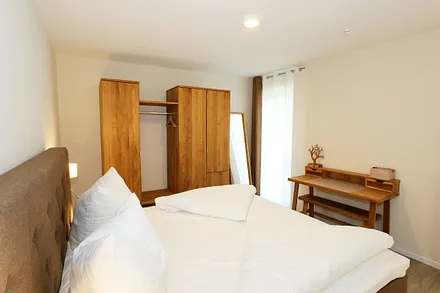 Schlafzimmer ist mit einem Boxspringbett (1,80 m x 2,00 m), durchgehenden Topper, Nachttischablagen, Kosmetiktisch, Kleiderablage sowie einen Kleiderschrank