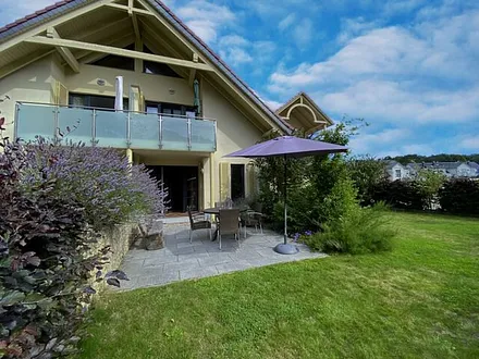 bestuhlte Terrasse (Süd/Ost) mit Sonnenschirm und einem Weber-Holzkohlegrill