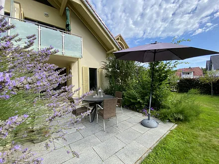 bestuhlte Terrasse (Süd/Ost) mit Sonnenschirm und einem Weber-Holzkohlegrill