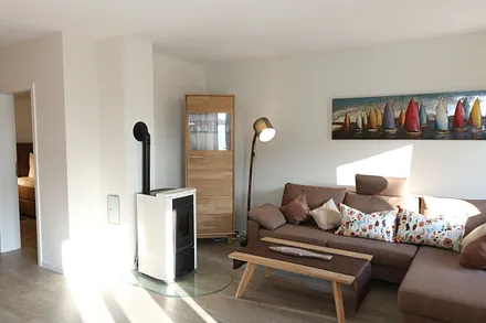 Wohn-/Küchenbereich mit hochwertigen Massivholzmöbeln, Couch ( Aufbettung für 3. Person 0,90 m x 2,00 m), Couchtisch, Leselampe, Kamin Pelletofen, TV-Board mit Smart-TV sowie eine Bose Soundbar