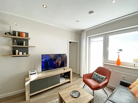 Wohnzimmer mit Stuhl und TV