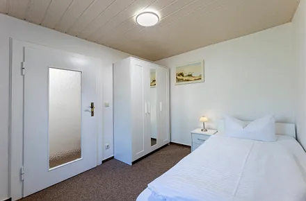 Schlafzimmer mit Einzelbett und Kleiderschrank