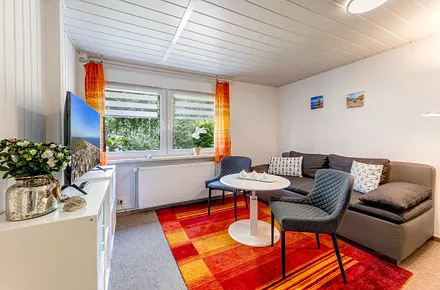 Wohnzimmer mit Sitzbereich, Couch und TV