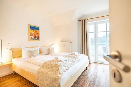 Schlafzimmer mit Doppelbett und angrenzendem Balkon