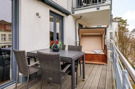 Der bequem möblierte Balkon mit einem Strandkorb statt Sonnenliegen.