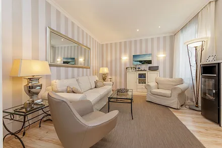 Das Wohnzimmer mit Bioethanol-Kamin, TV, DVD-Player und HiFi-Anlage mit CD-Player.