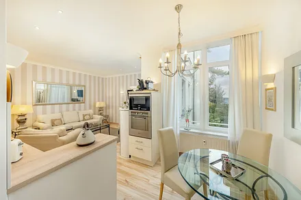 Blick über die Küchenzeile mit Backofen und Mikrowelle in den Wohnraum.