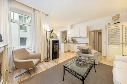 Der Blick zur Küchenzeile mit Geschirrspüler, 4-Platten-Cerankochfeld und Kühlschrank mit Eisfach.