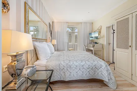 ... TV, Kleiderschrank und Durchgang zum verglasten Balkon.