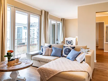 Auf der Couch kann aufgebettet werden. Im Hintergrund der Austritt zum Balkon.