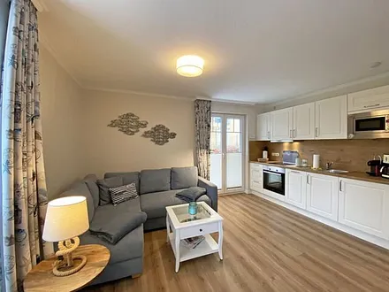 Wohnbereich mit gemütlicher Couch (Aufbettung für die 3. Person, Liegefläche 1,60 m x 2,00 m), Couchtisch, Leselampe, Lowbord mit Smart-TV, DAB-Radio mit USB-Anschluss sowie Bluetooth Anschluss